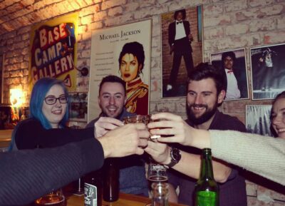 Authentic Prague nightlife scene with travelers and locals toasting inside a retro bar in Letná