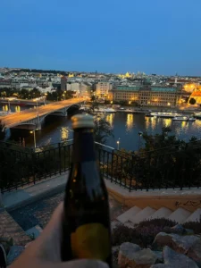 Night view of Prague with a beer in hand from Letná Park overlooking the Vltava River and city lights