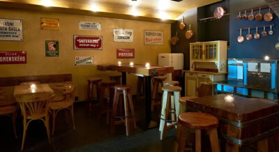 "Hidden local bar in Letná with retro Czech street signs and a warm, intimate vibe